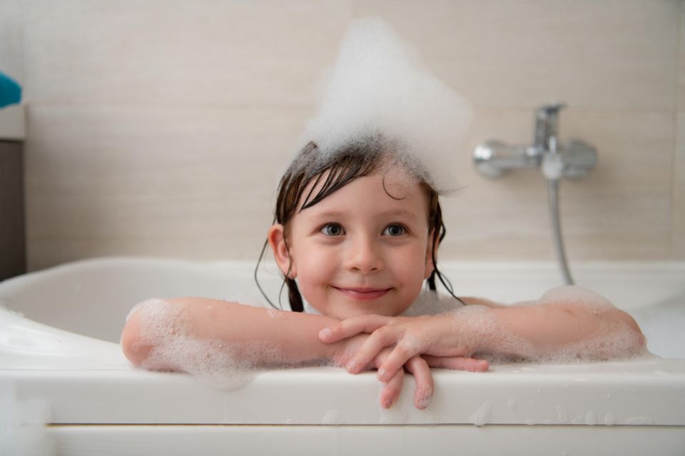 Familienleben: Kind badet in der Badewanne