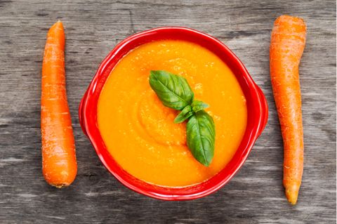 Morosche Karottensuppe: Schüssel mit Karottensuppe und zwei Möhren