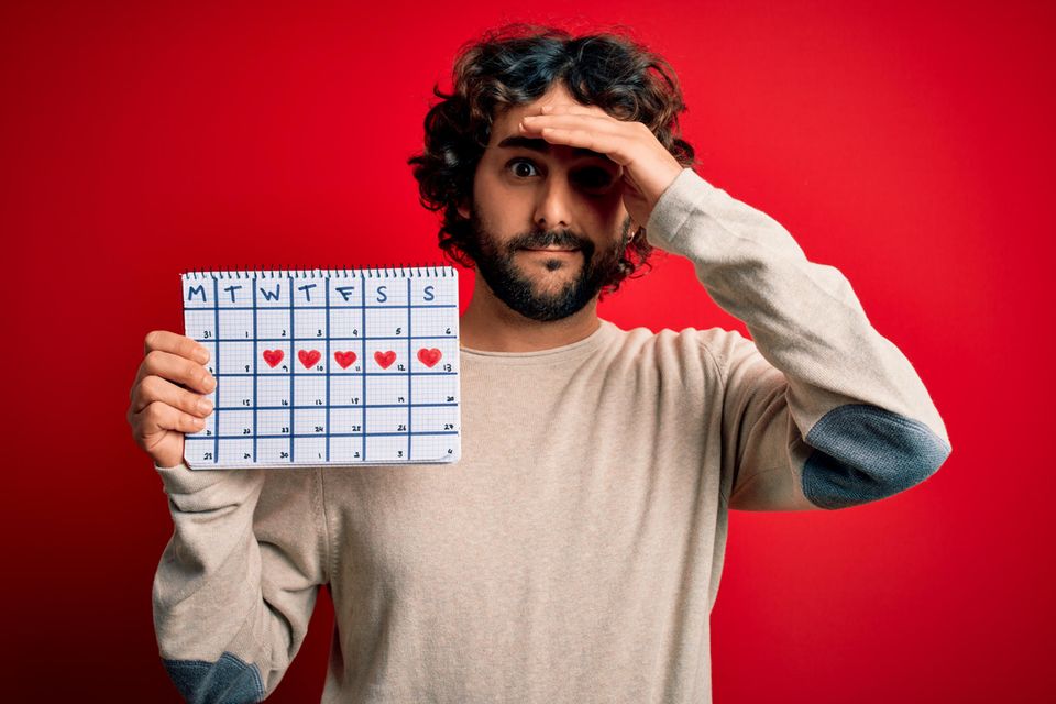 Menstruation: Mann hält ZyklusKalender in der Hand