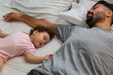 Elternzeit: Vater schläft neben kleinem Mädchen