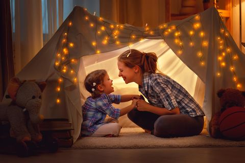 Muttersein: Mutter und Kind spielen im Zelt