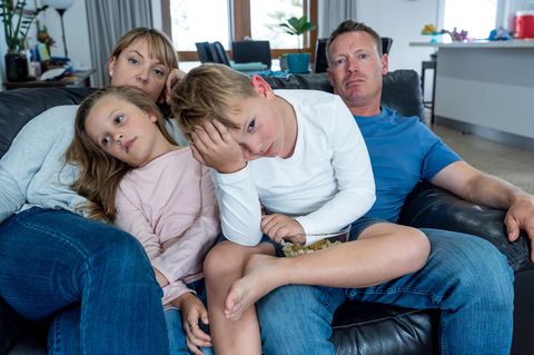 Familienleben: Familie sitzt genervt auf dem Sof