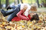 Baby: Mutter und Kind spielen in Herbstblätter