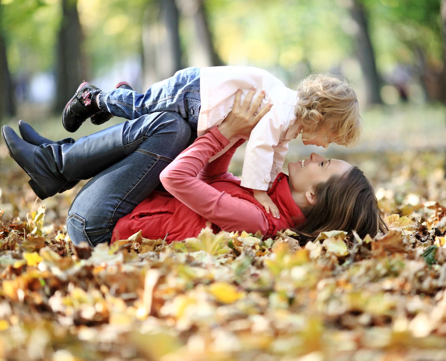 Baby: Mutter und Kind spielen in Herbstblätter