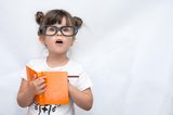 Kind mit Brille und Notizbuch