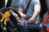 Baby-Schlaf: Vater schnallt Baby im Auto an