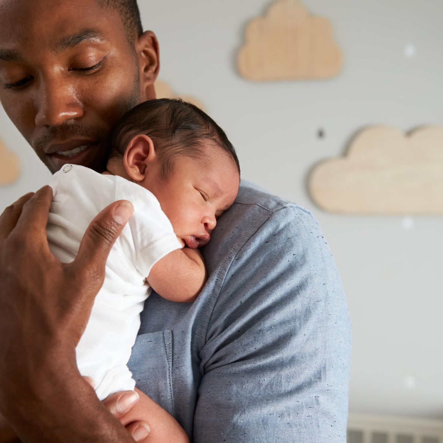 Alltag mit Kind: Vater trägt schlafendes Baby