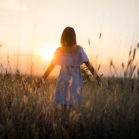 Neurologie: Eine Frau auf einem Feld im Sonnenuntergang