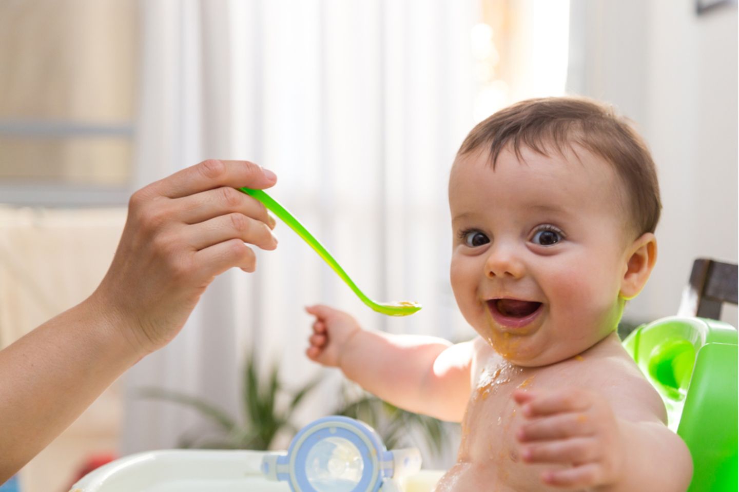 Abendbrei: Baby wird gefüttert und lacht