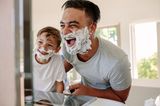 Papa und Sohn lachen beim rasieren