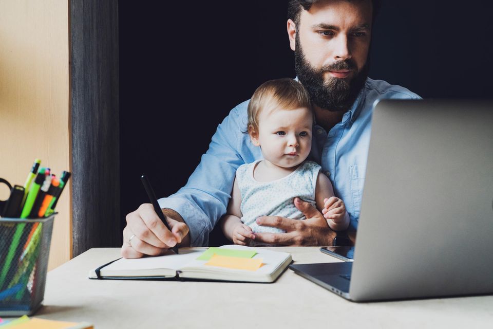 Mehr Geld für die Familie: Vater mit Kind vor dem Laptop