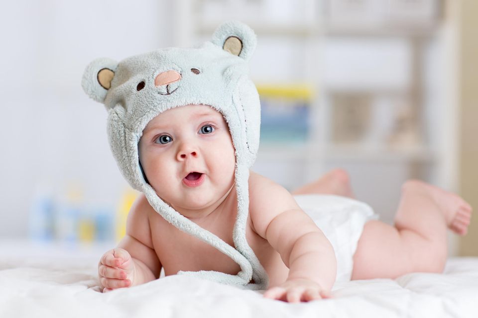 Babykleidung: Baby mit großer Mütze