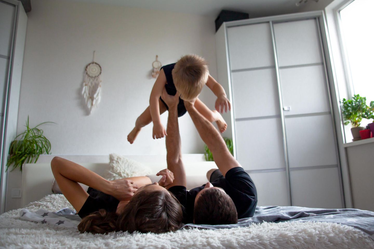 Väter-Fitness im Babyalltag: Vater spielt Flieger mit Kind