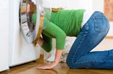 Süße Rettung: Frau sucht etwas in der Waschmaschine