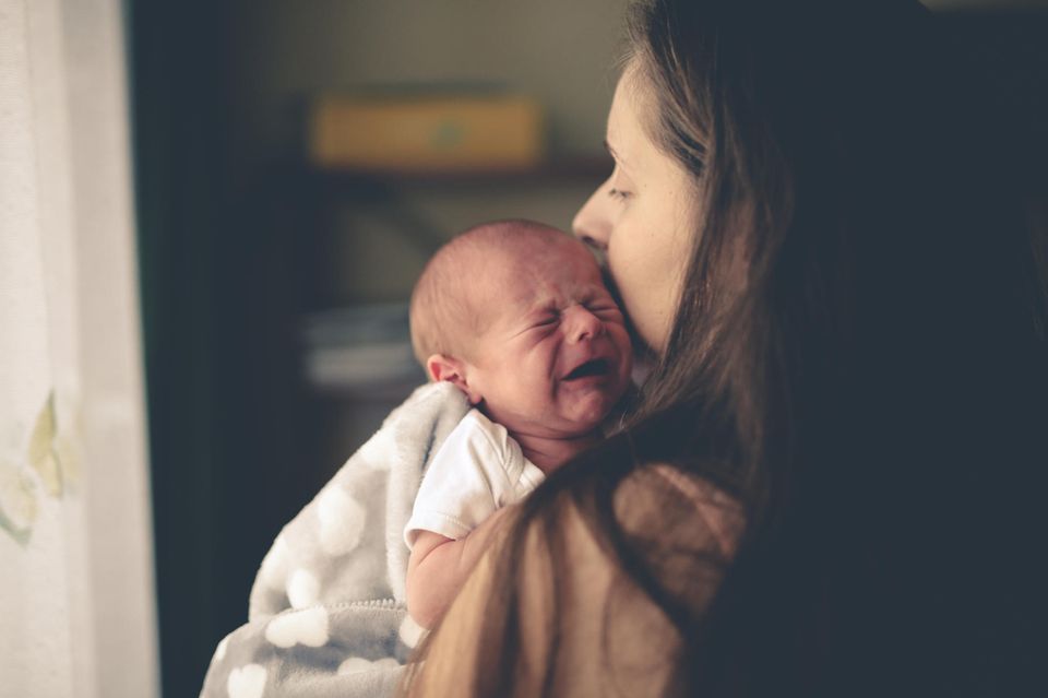 Süße Rettung: Schreiendes Baby auf Arm der Mutter