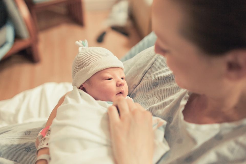 Geburt: Mutter hält Neugeborenes im Arm