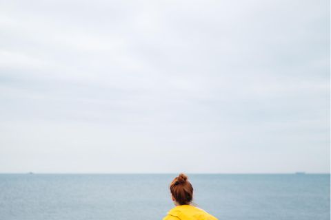 Warum finden Frauen schwerer einen neuen Partner: Frau sitzt alleine am Meer