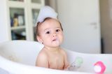 Kleinkinder: Kleinkind mit Schaum auf dem Kopf in der Badewanne