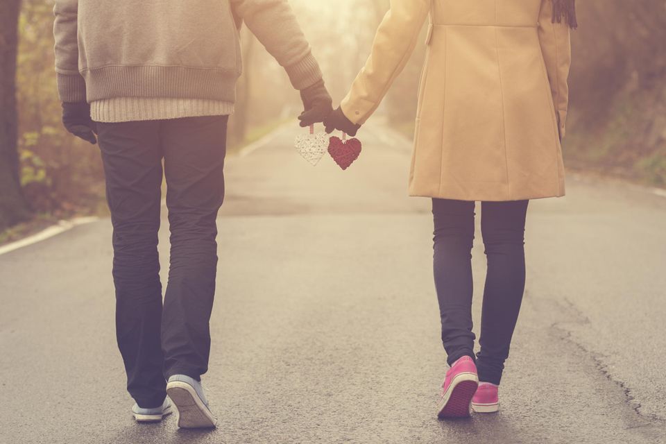Woran glauben glückliche Paare? Ein Paar geht Hand in Hand spazieren