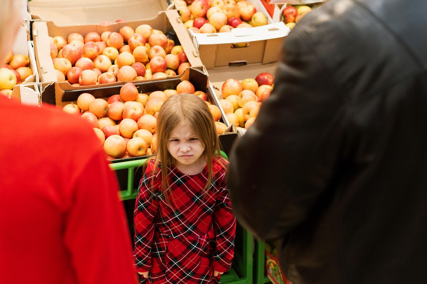 Einkaufen mit Kindern: Eltern mit bockiger Tochter im Supermarkt