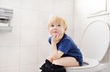 Familienleben: Junge auf Toilette