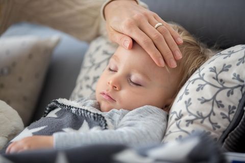Krankes Kind: Mutter legt die Hand auf die Stirn