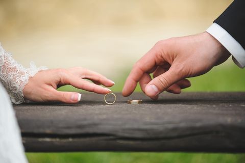 Whisper: Zwei Hände eines Brautpaares mit Eheringen