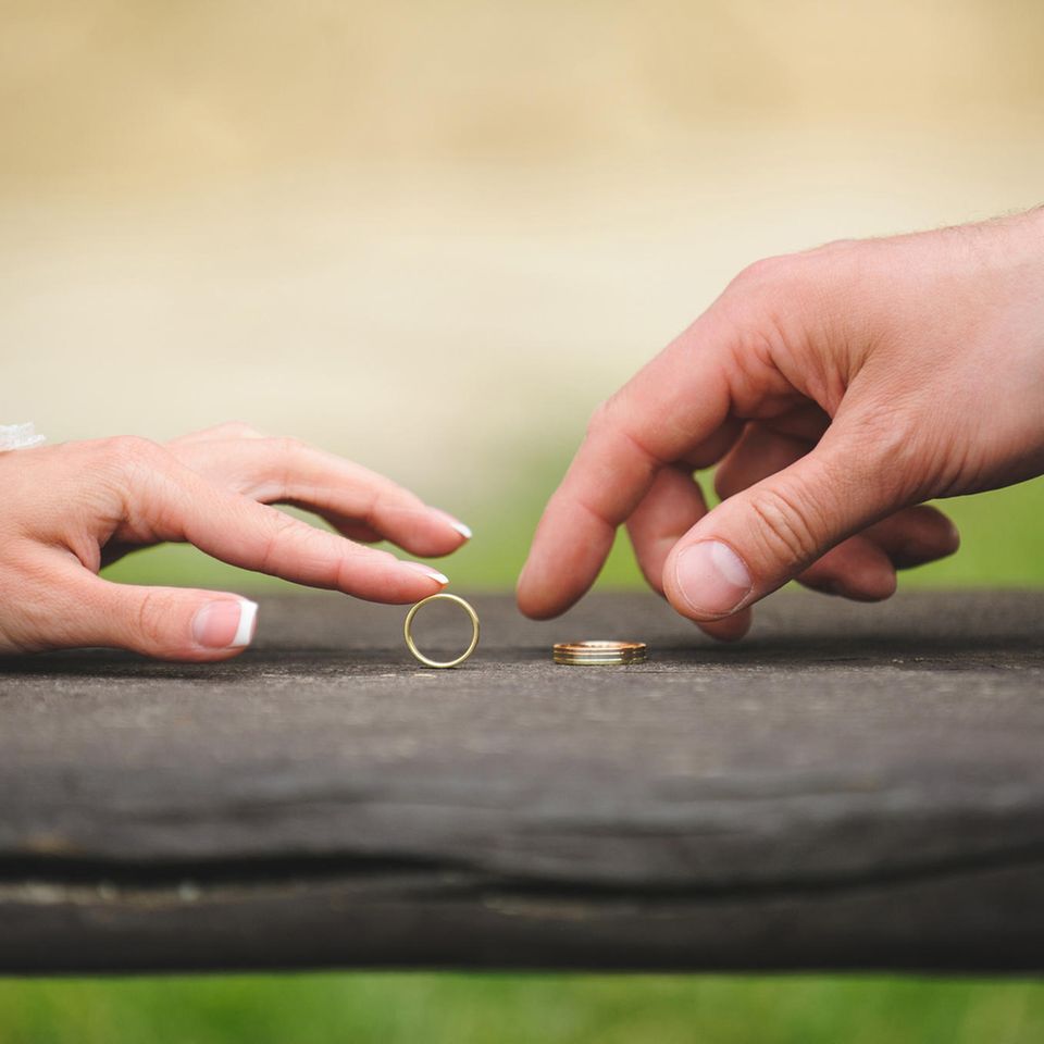 Whisper: Zwei Hände eines Brautpaares mit Eheringen