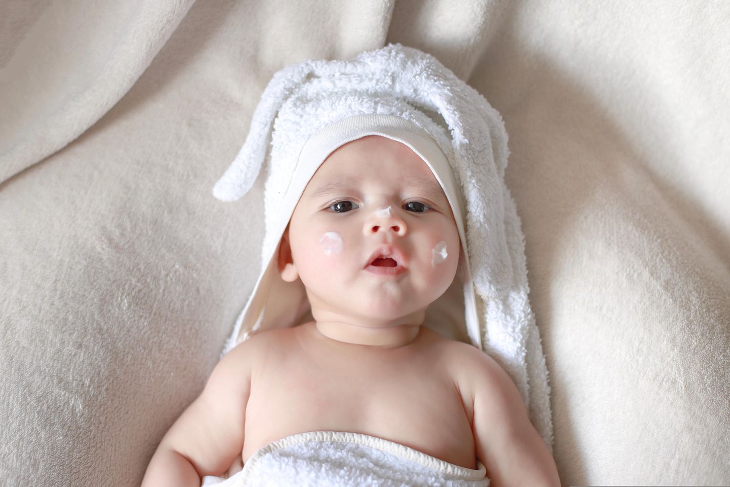 Öko-Test: Baby mit Creme im Gesicht