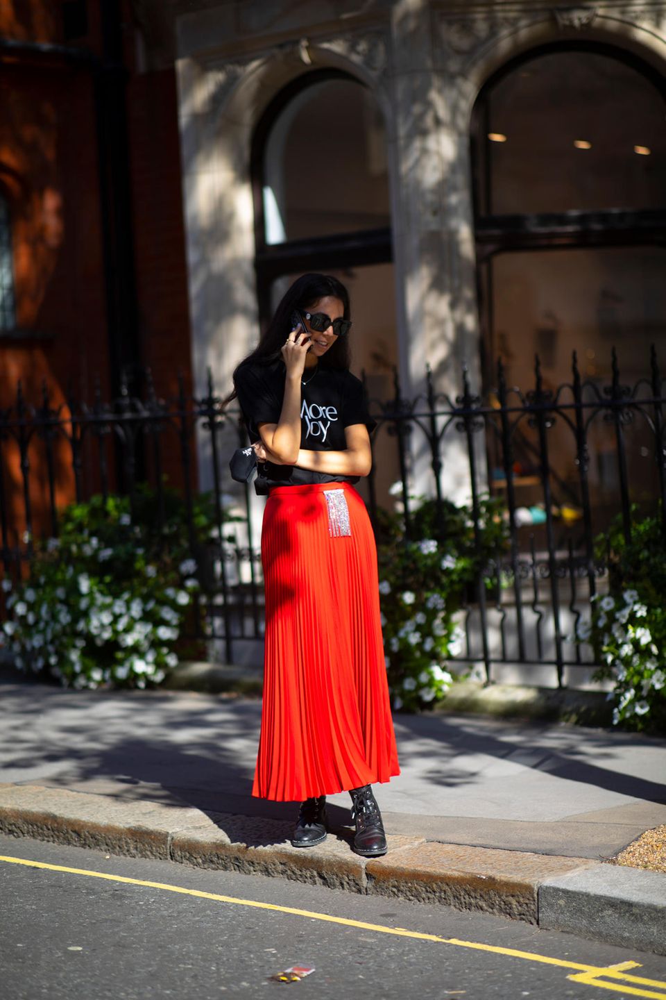 Streetstyle Fashionweek: Roter pliseerock mit schwarzem Shirt