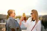 Zwei Freundinnen stoßen mit Bier an