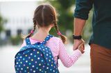Kinderbetreuung: Mädchen an der Hand eines Mannes