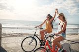 Zwei Freundinnen fahren zusammen Fahrrad