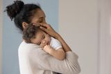 Husten, Schnupfen, Heiserkeit: Mutter umarmt ihr Kind auf dem Arm