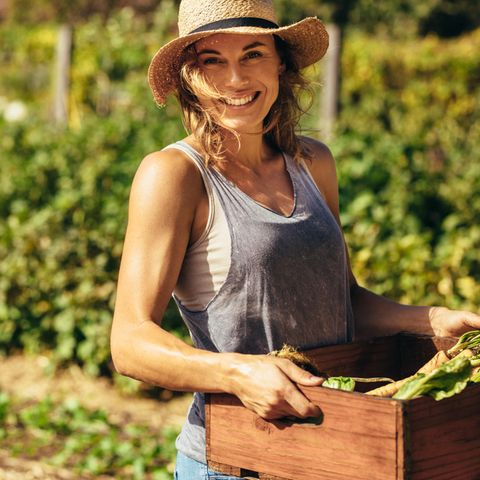 Autark leben: Frau hält Gemüsekiste in der Hand