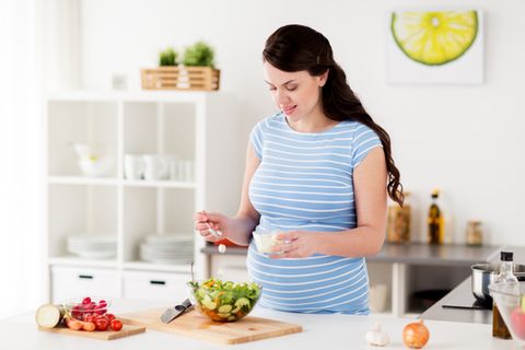 Mozzarella in der Schwangerschaft: Schwangerer bereitet Salat zu