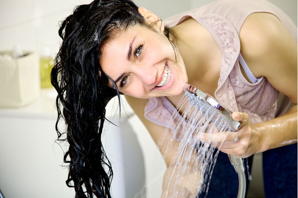 Shampoo ohne Silikone: Frau wäscht sich mit Shampoo die Haare.