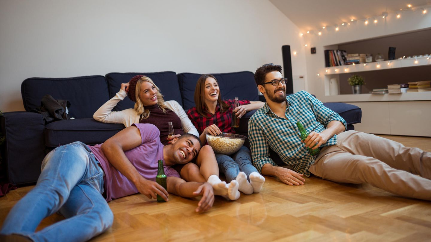 Eine Gruppe von Freunden sitzt vor dem Fernseher und schaut einen Film