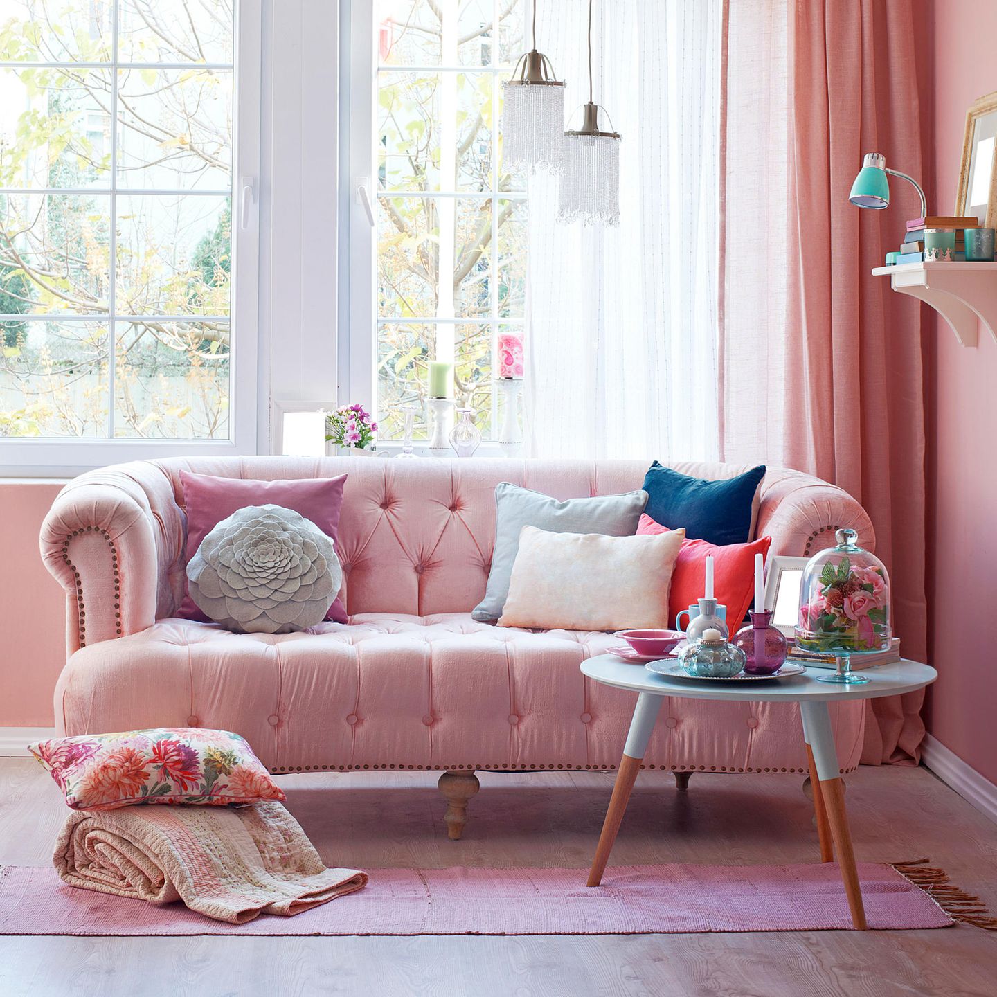 Wer es blushfarben, aber dennoch knallig mag, setzt große Wohnakzente wie dieses Sofa, umhüllt von einem Blush-Teppich und -Vorhängen.