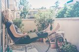 Eine Frau sitzt auf dem Balkon und träumt