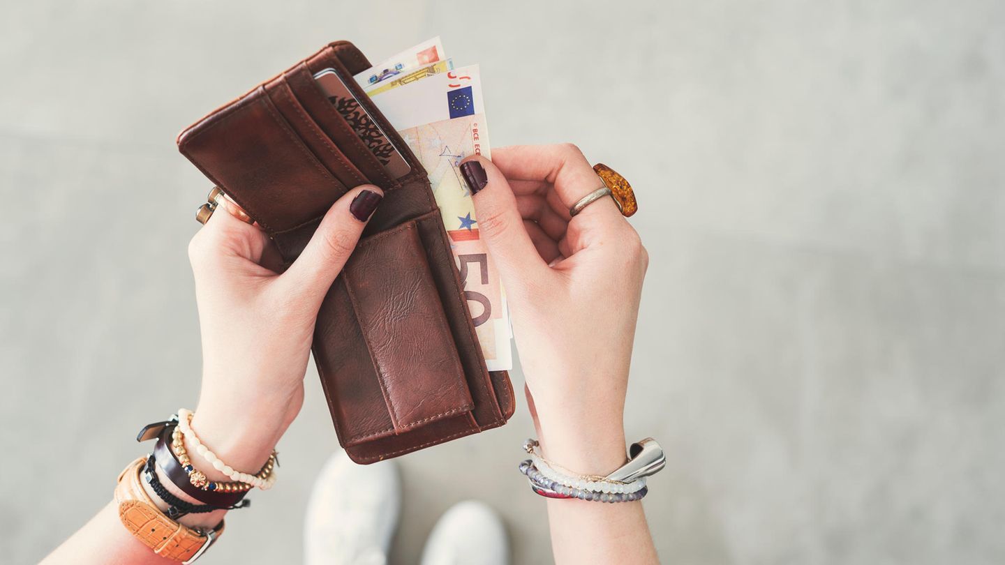 Eine Frau mit viel Geld im Portemonnaie
