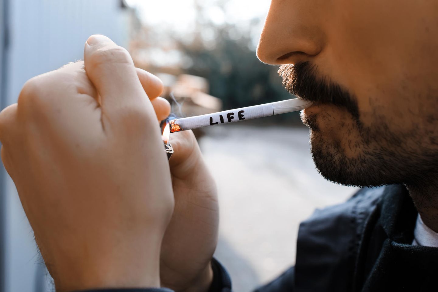 Rauchen: Mann zündet sich Zigarette an