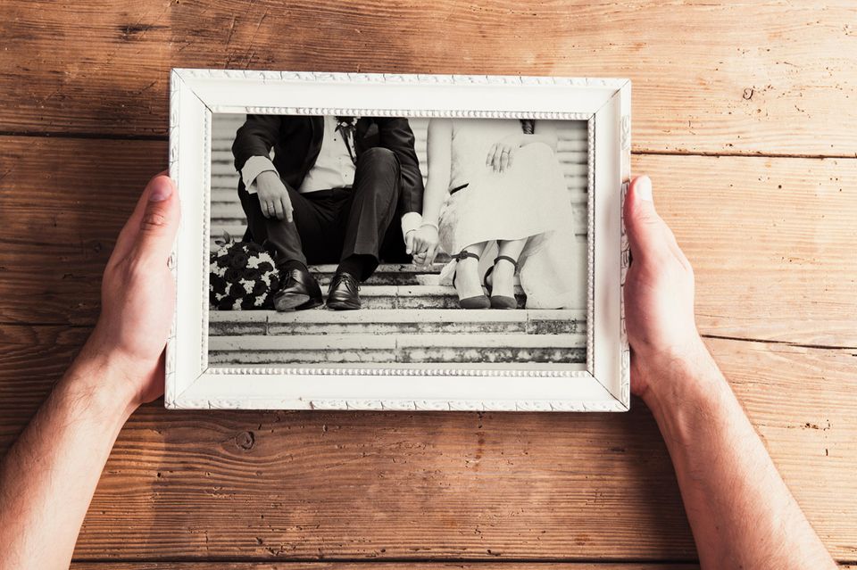 Whisper: Ein Mann hält ein Schwarz-Weiß-Foto in einem Rahmen in den Händen