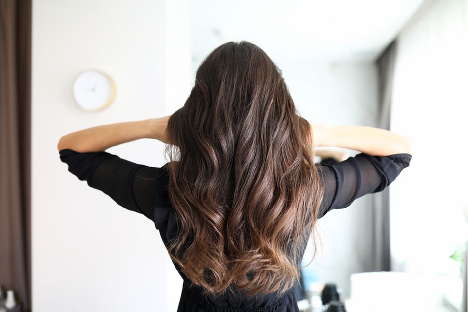Haarwachstum anregen: Frau von hinten mit langen gewellten Haaren.