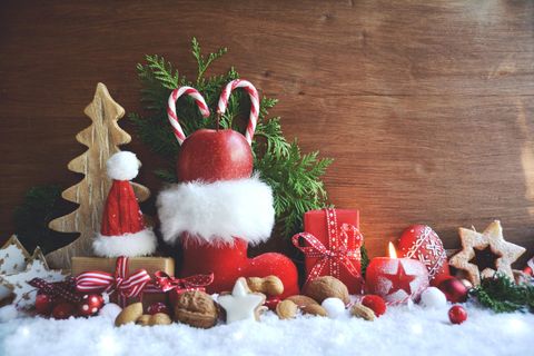 Nikolaus-Geschenkideen: roter Nikolausstiefel, Nüsse, Zimtsterne, Kunstschnee, Tannenzweig, kleine Geschenke, Weihnachtsdeko