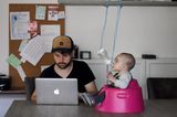 Abenteuerliche Babyfotos: Vater am Laptop und Baby auf Topf