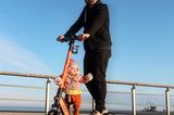 Abenteuerliche Babyfotos: Vater mit Baby auf Roller