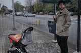Abenteuerliche Babyfotos: Vater mit Kinderwagen im Regen