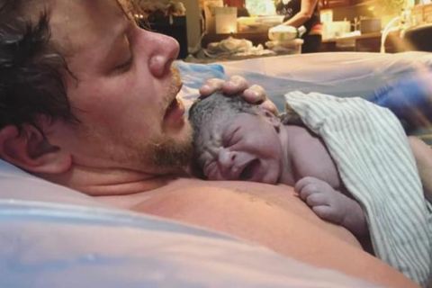 trans Vater: Er hält sein Baby im Arm