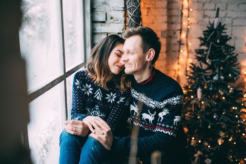 Horoskop: Liebeserklärung vor Weihnachten: Paar am Fenster